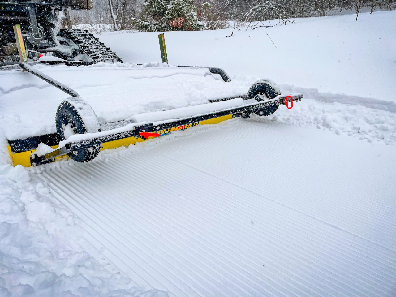 UTV towing snow groomer